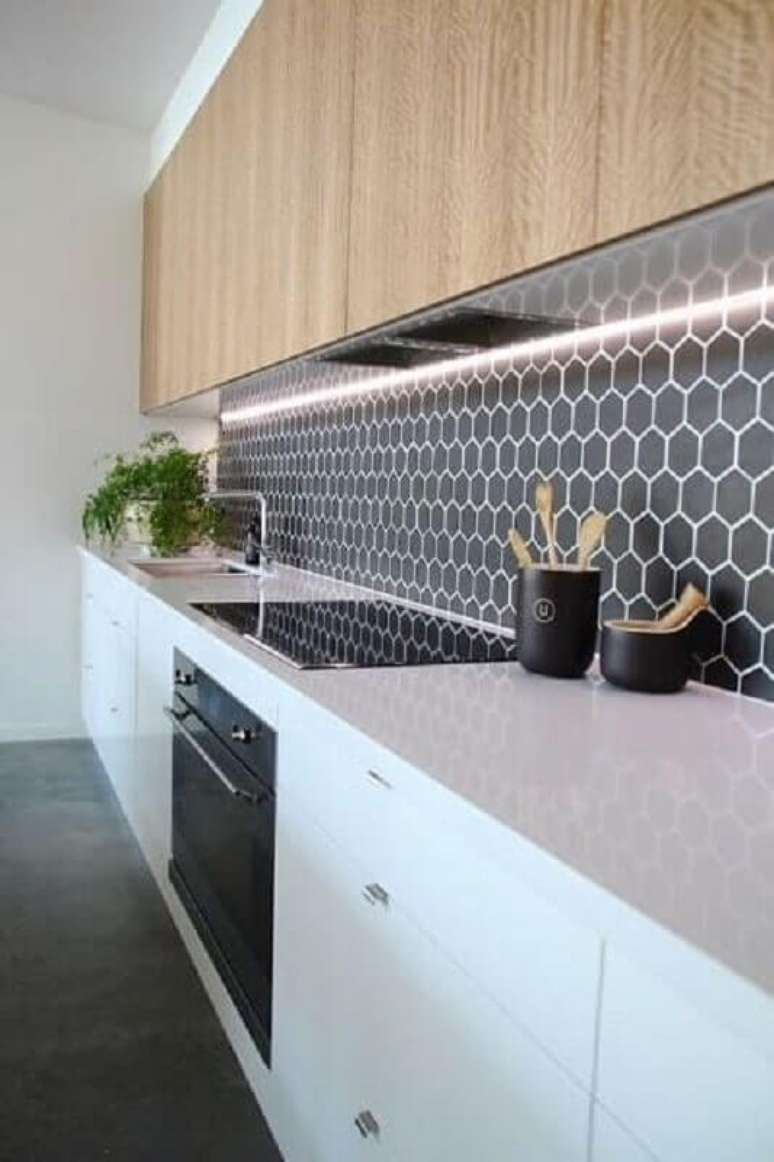 57. Revestimento hexagonal cinza escuro para decoração de cozinha com armário aéreo de madeira – Foto: Jeito de Casa