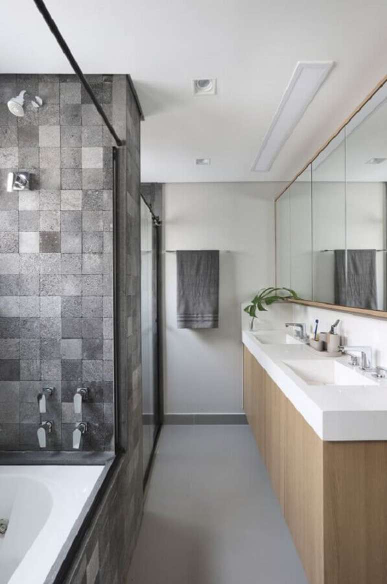 55. Revestimento cinza quadriculado para banheiro decorado com gabinete de madeira &ndash; Foto: Quattrino Arquitetura