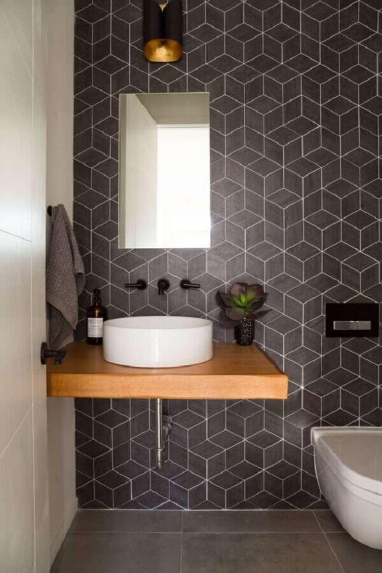 2. Banheiro decorado com bancada de madeira e revestimento cinza escuro geométrico – Foto: Moran Anders Arquitetura