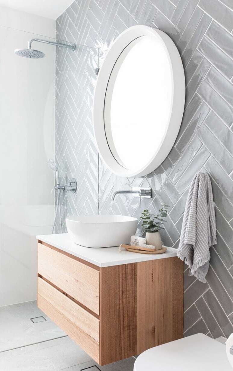 47. Revestimento cinza claro para banheiro clean decorado com gabinete suspenso de madeira – Foto: Pinterest
