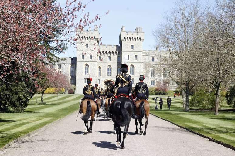 membros da cavalaria real com uniformes cavalgam até o castelo de Windsor