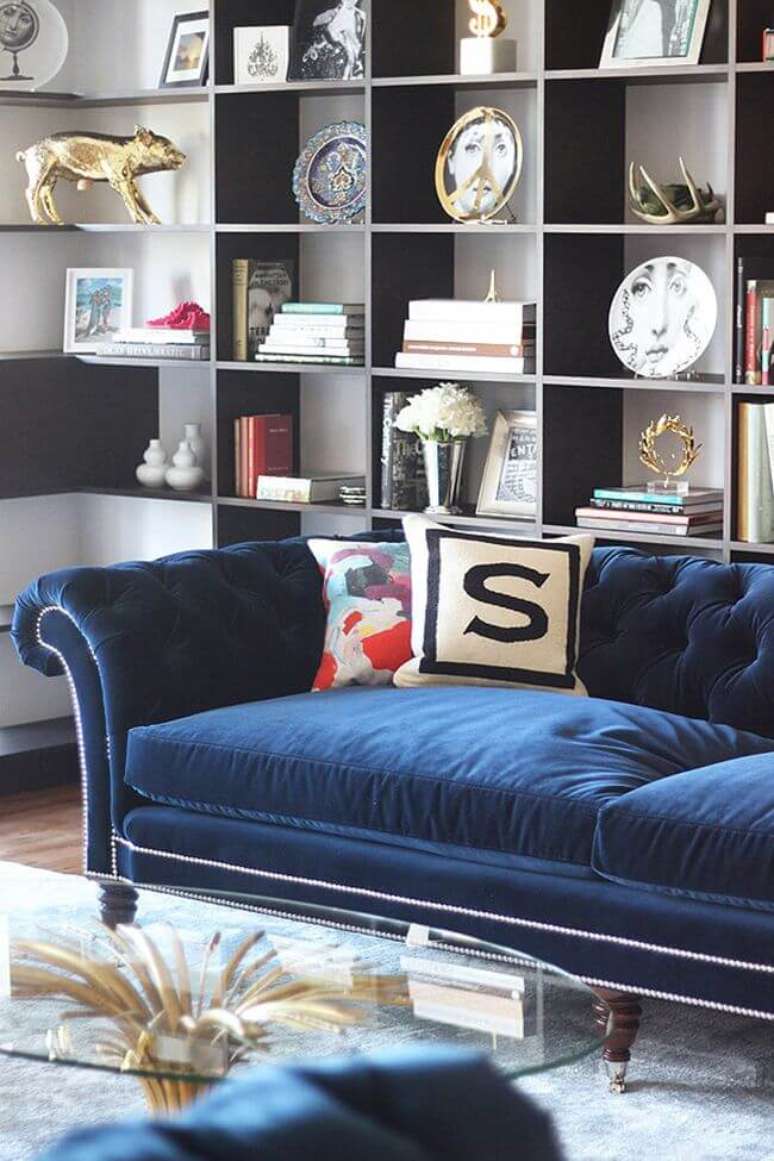 57. Sofá azul marinho na sala com estante cheia de enfeites – Foto Pinterest