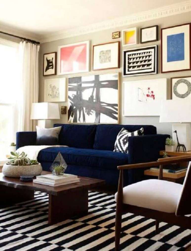 31. Sala com sofá azul marinho e conjunto de quadros na parede – Foto Dimples and Tangles