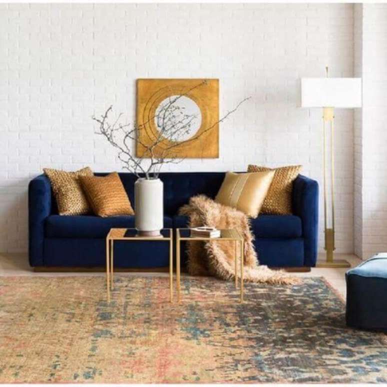 40. Sala moderna com sofá azul marinho e enfeites dourados – Foto Surya