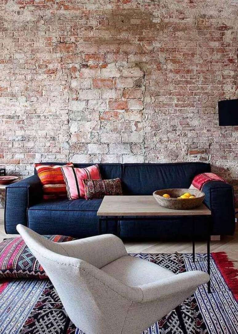 30. Sala com parede de tijolinho rustico e sofá azul marinho – Foto Blue Door Living