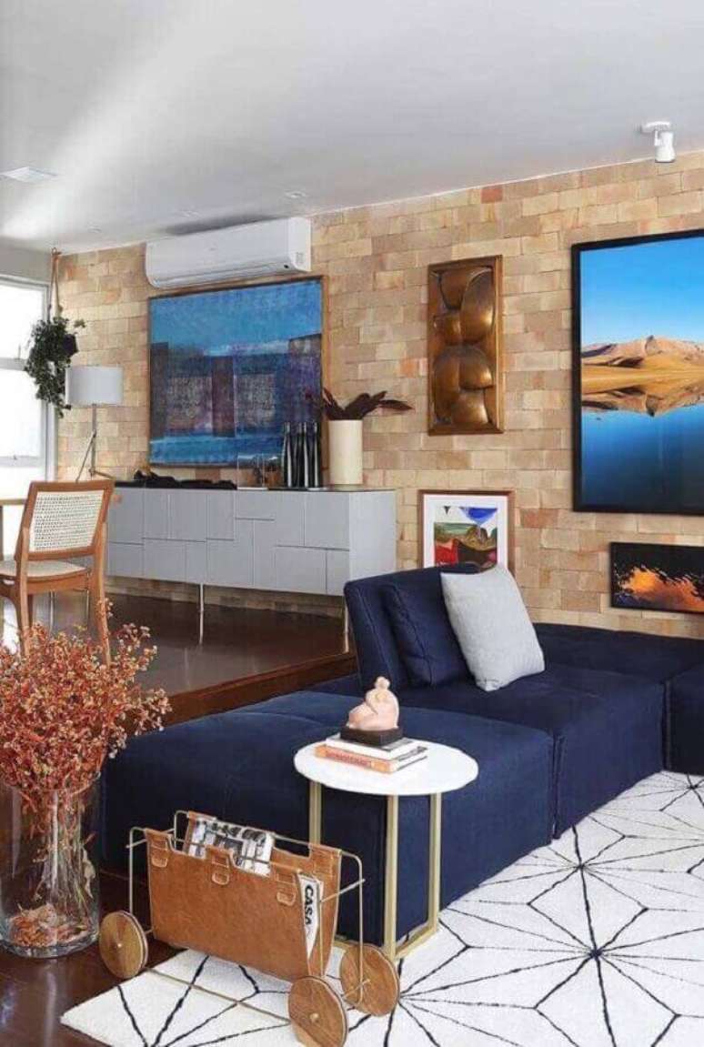 39. Sala moderna com sofá azul marinho e parede de tijolinho – Foto Ideias Decor