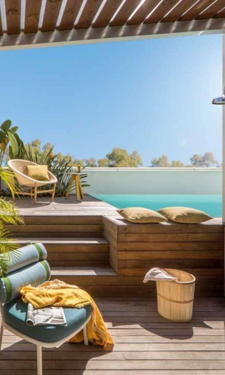 4. Piscina elevada com deck de madeira e móveis confortáveis para tomar sol – Foto Pinterest
