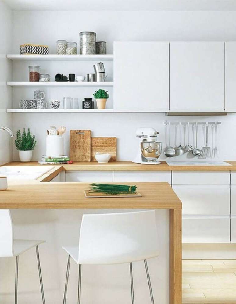 8. Decoração clean para cozinha com balcão de madeira e armários brancos – Foto: Elle Décoration