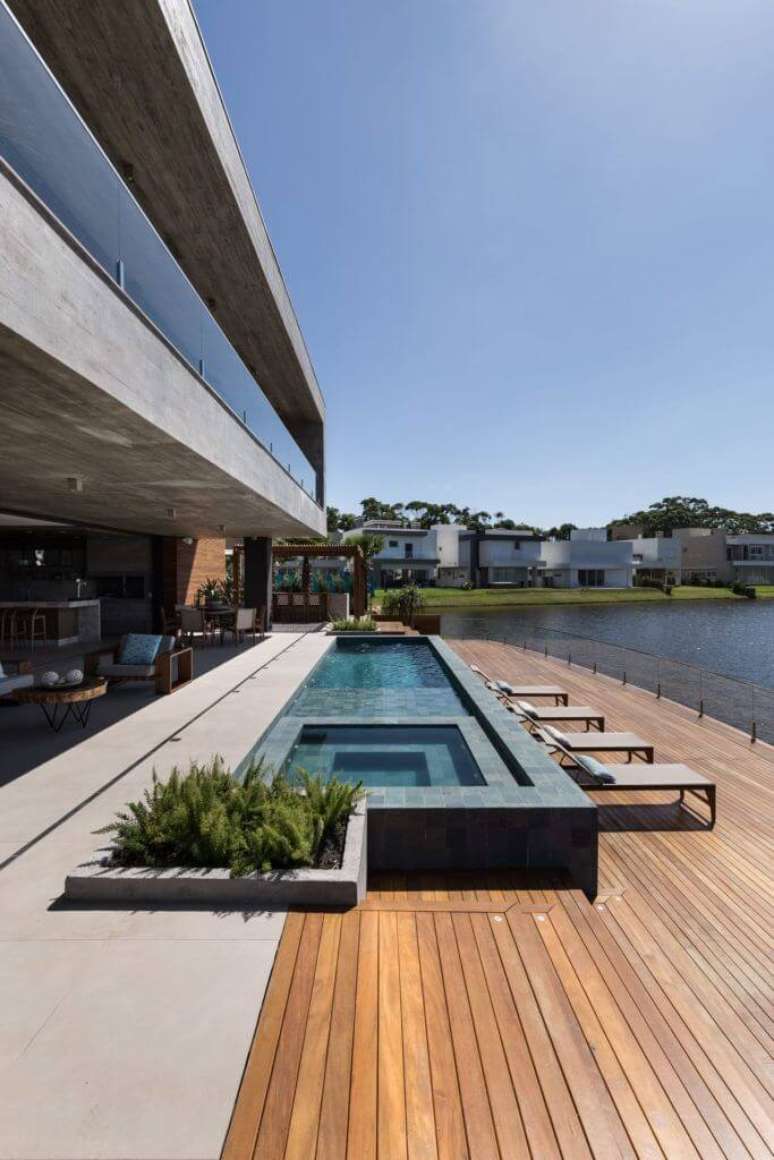 59. Piscina com revestimento de pedra preta e deck de madeira  – Foto Martin Arquitetura + Engenharia