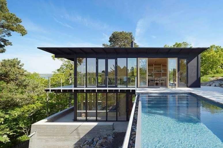 67. Casa de fazenda com fachada de vidros e piscina com borda infinita. Fonte: Pinterest