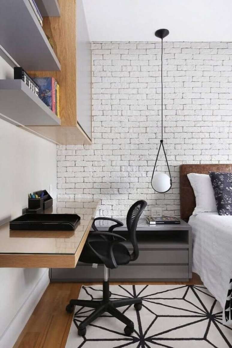 14. Cadeira de estudo para quarto decorado com bancada de madeira suspensa e parede de tijolinho branco – Foto: Zuleide Borges