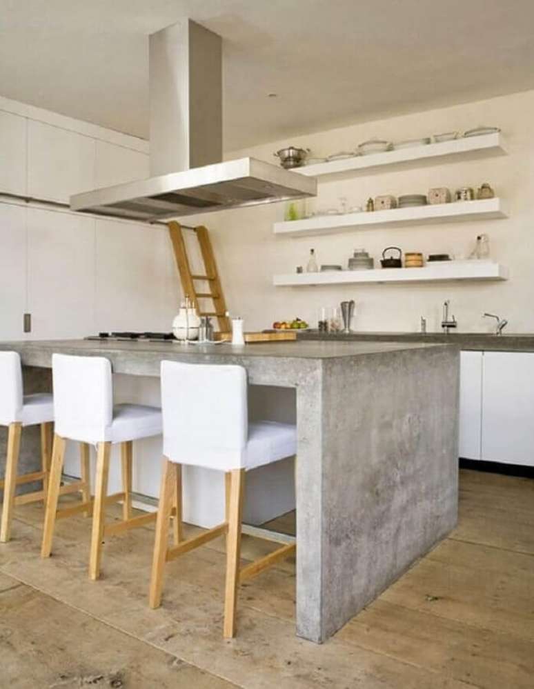 30. Bancada de cozinha de cimento queimado e prateleiras brancas decoram o ambiente. Fonte: Você Precisa Decor