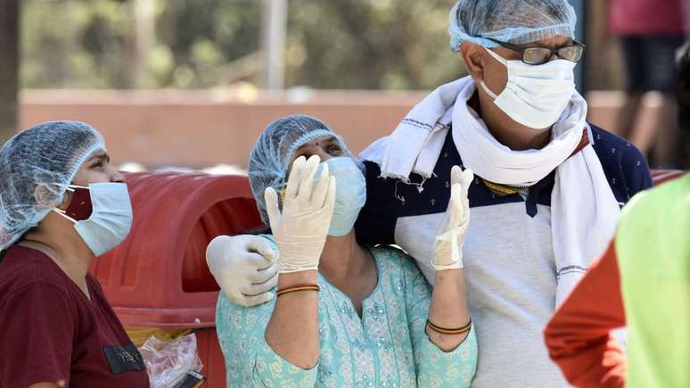 Equipe médica lamentando mortes por coronavírus em Kuvadava, uma vila em Gujarat