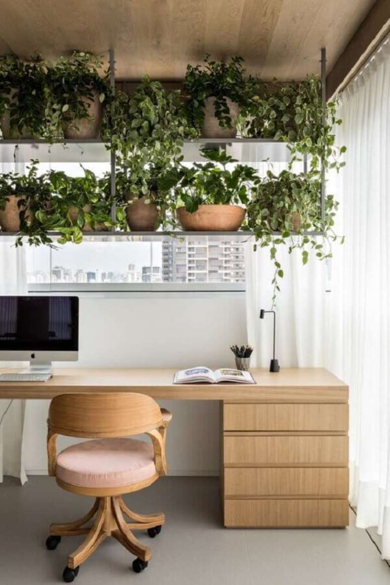 41. Modelo de cadeira de estudo moderna para decoração de varanda com escrivaninha de madeira e vasos de plantas – Foto: Archdaily