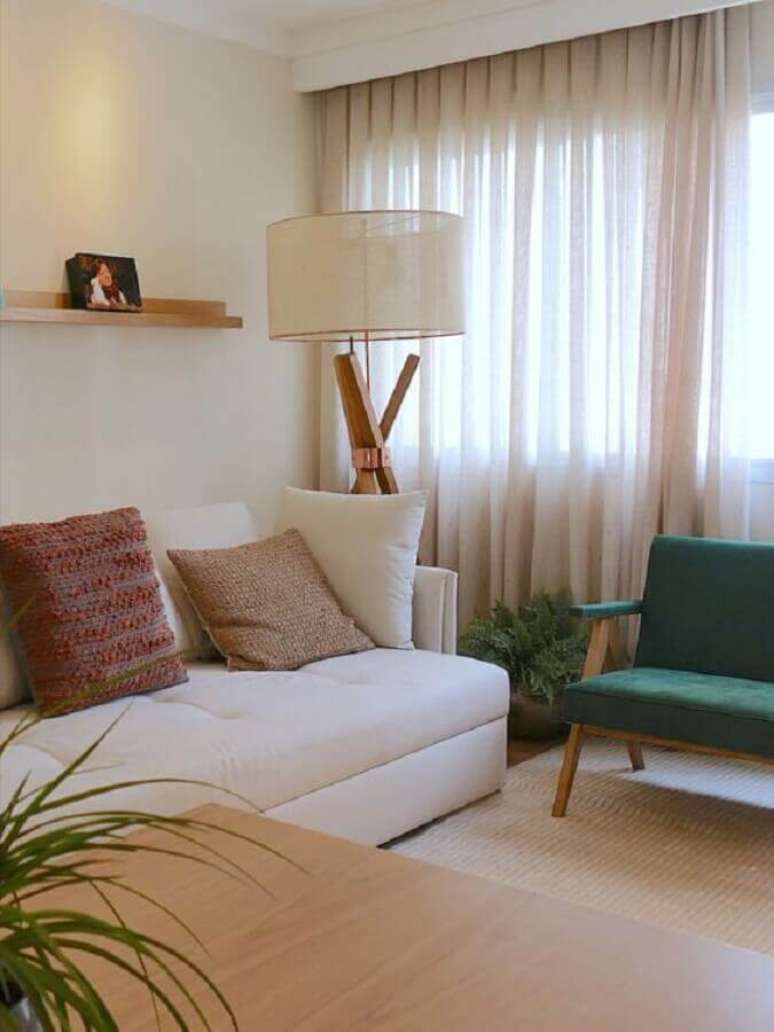 32. Decoração em cores neutras com almofadas para sala com poltrona verde de madeira – Foto: Comparato Arquitetura