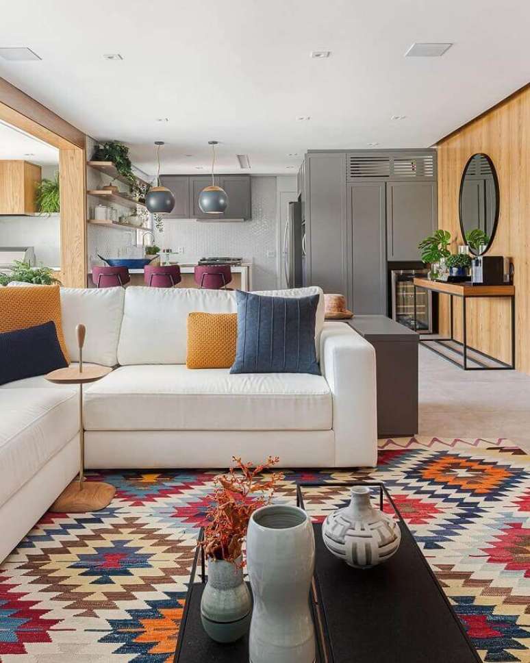 45. Tapete colorido e almofadas para sala de estar ampla decorada com sofá branco de canto – Foto: Pinterest