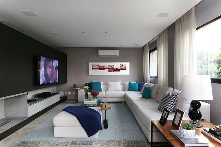 57. Almofadas para sala de TV ampla decorada com sofá de canto branco – Foto: Hidebrand Silva Arquitetura