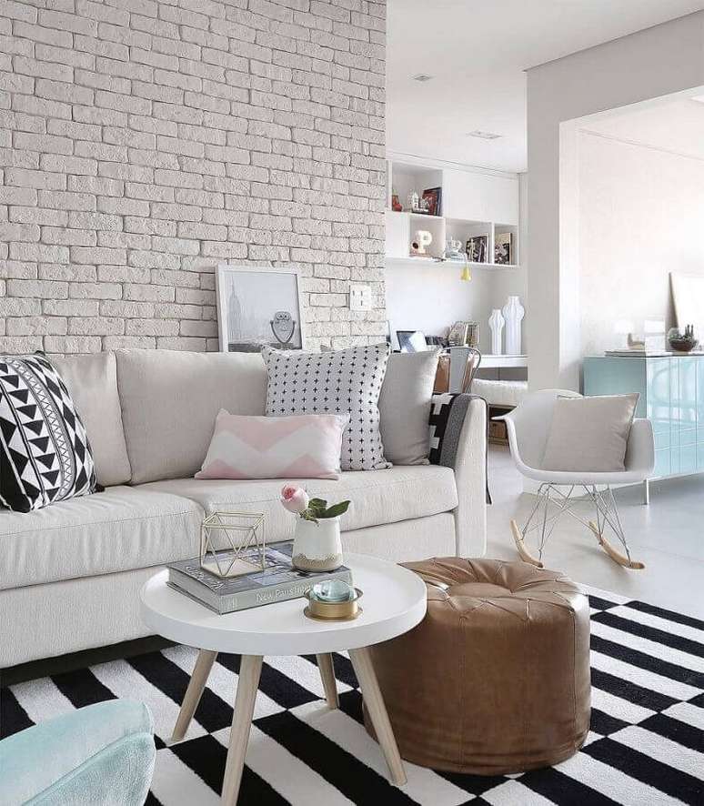 19. Almofadas diferentes para sala branca decorada com parede de tijolinho e tapete listrado – Foto: Pinterest