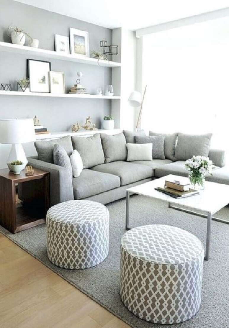31. Decoração em tons de cinza claro com almofadas para sala com puff redondo e sofá de canto – Foto: Pinterest