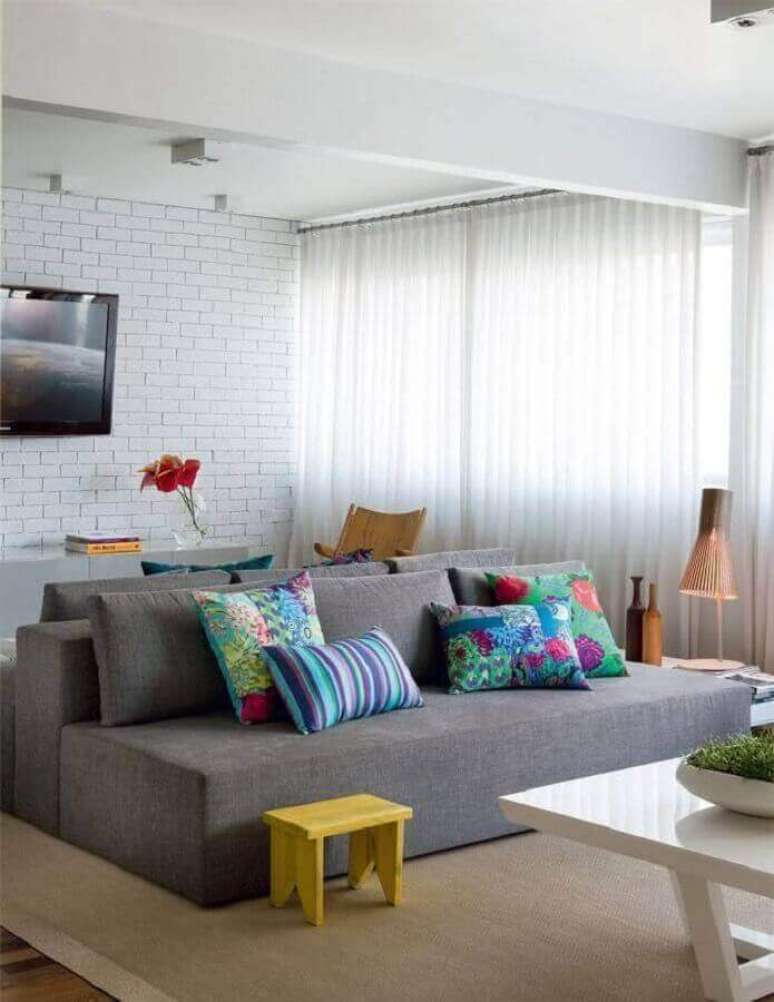 34. Almofadas para sala de TV decorada com sofá sem braço cinza e parede espelhada – Foto: Arquiteto Gourmet