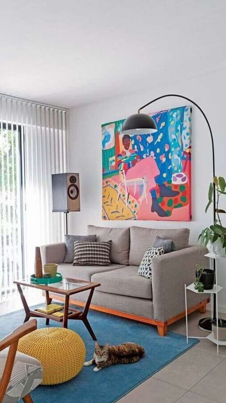 16. Decoração com almofadas para sala com sofá pequeno e quadro colorido grande – Foto: Pinterest