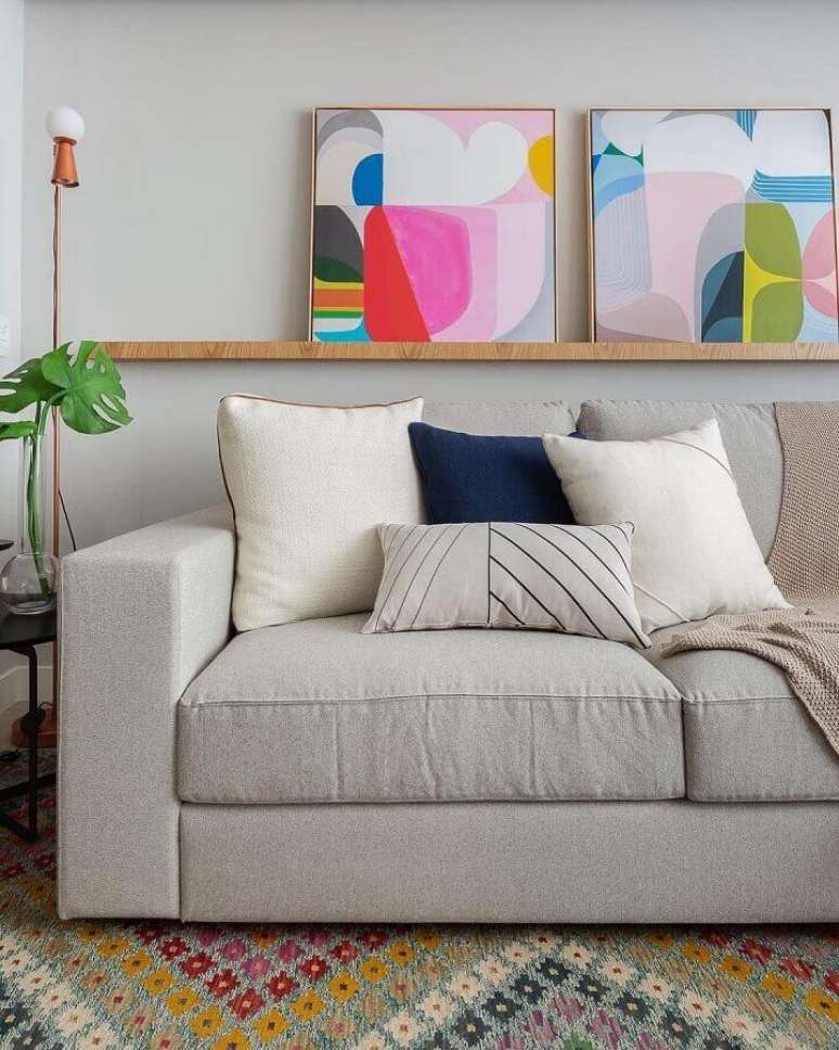 44. Quadros coloridos e almofadas para sala de estar moderna decorada com sofá cinza claro – Foto: Casa de Valentina