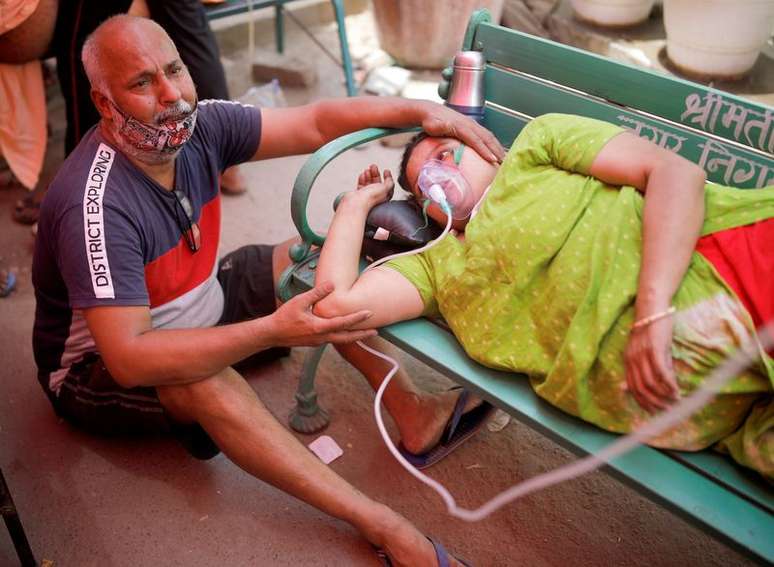 Homem ao lado da esposa que recebe suporte de oxigênio do lado de fora de templo em Ghaziabad, na Índia
03/05/2021 REUTERS/Adnan Abidi