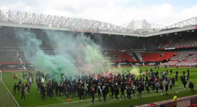 Torcedores do Manchester United invadiram o gramado de Old Trafford (Foto: OLI SCARFF / AFP)