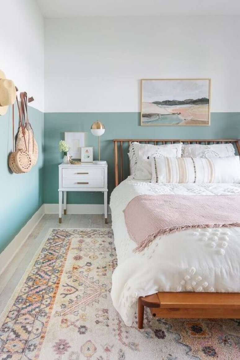 33. Decoração de quarto de casal com cama de madeira e meia parede pintada de azul claro – Foto: Apartment Therapy