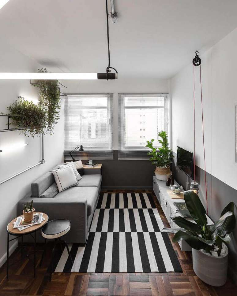 41. Decoração para sala de estar com tapete listrado e meia parede cinza e branca – Foto: Jeito de Casa