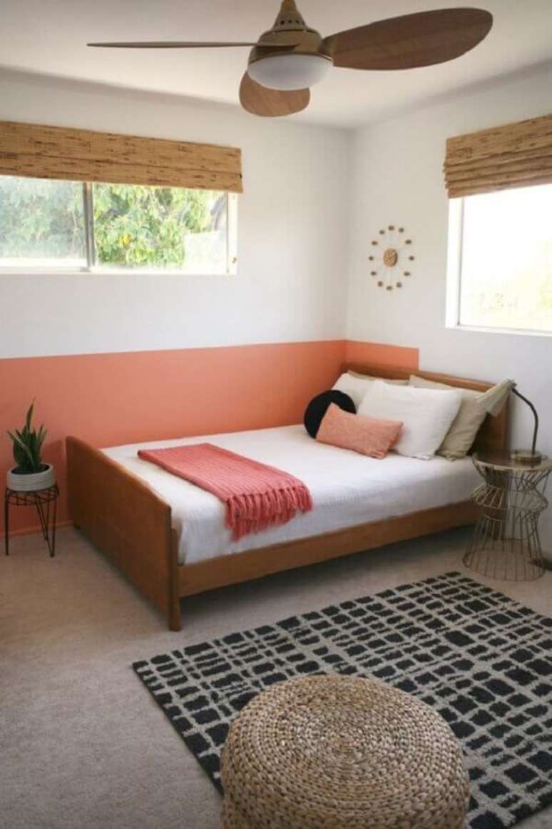 52. Quarto simples decorado com cama de madeira e meia parede rosa – Foto: Pinterest