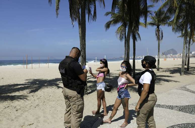 Guarda municipal multa duas mulheres que não usavam máscara na Praia do Leme, no Rio de Janeiro
20/03/2021 REUTERS/Ricardo Moraes