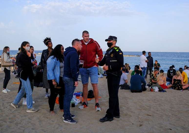 Polícia aborda pessoas em praia de Barcelona
 2/4/2021   REUTERS/Nacho Doce