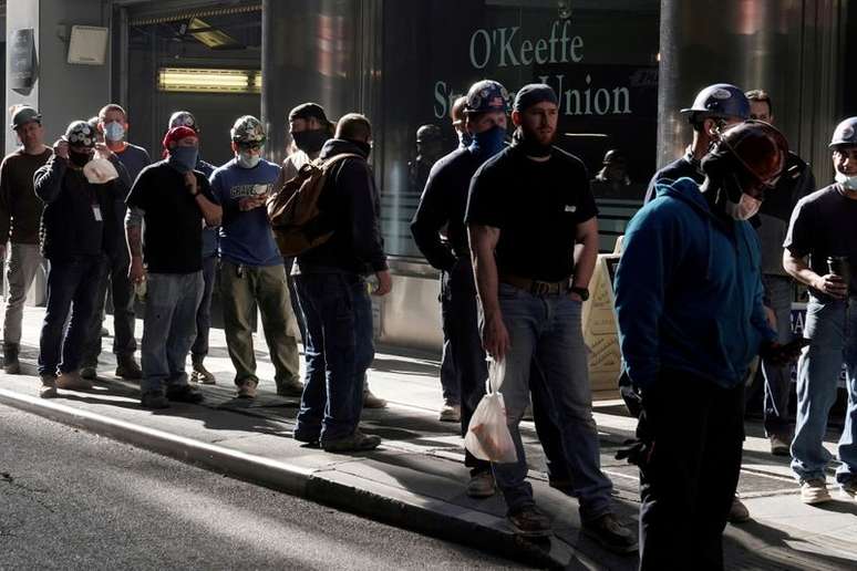 Trabalhadores de construção fazem fila para tirar temperatura ao volta ao trabalho do almoço em Nova York., November 10, 2020. REUTERS/Carlo Allegri