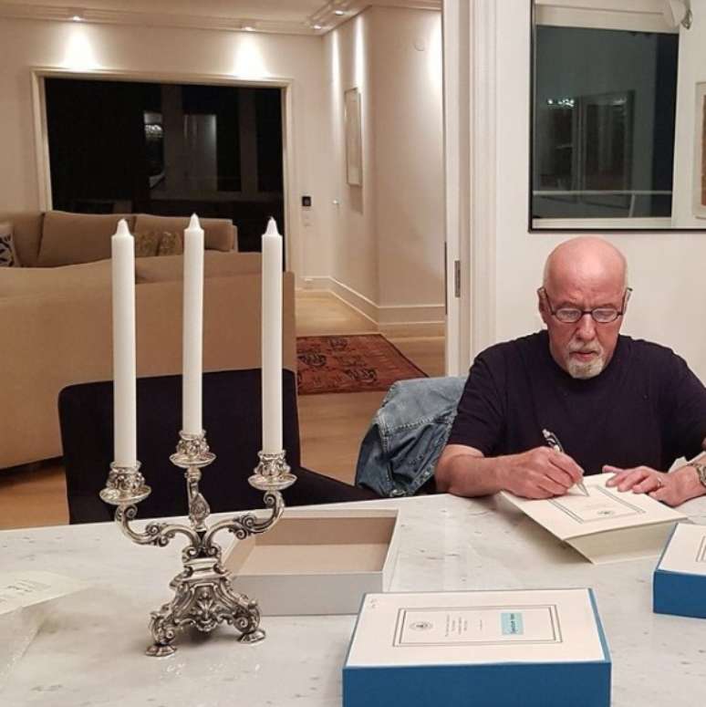 O imortal Paulo Coelho autografa livros em seu apartamento durante o lockdown na Suíça, ano passado