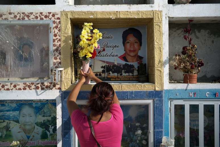 Hellen Ñañez, que perdeu 13 familiares para a Covid, visita túmulo de tia em cemitério de Pisco, no Peru 
09/05/2021
REUTERS/Alessandro Cinque