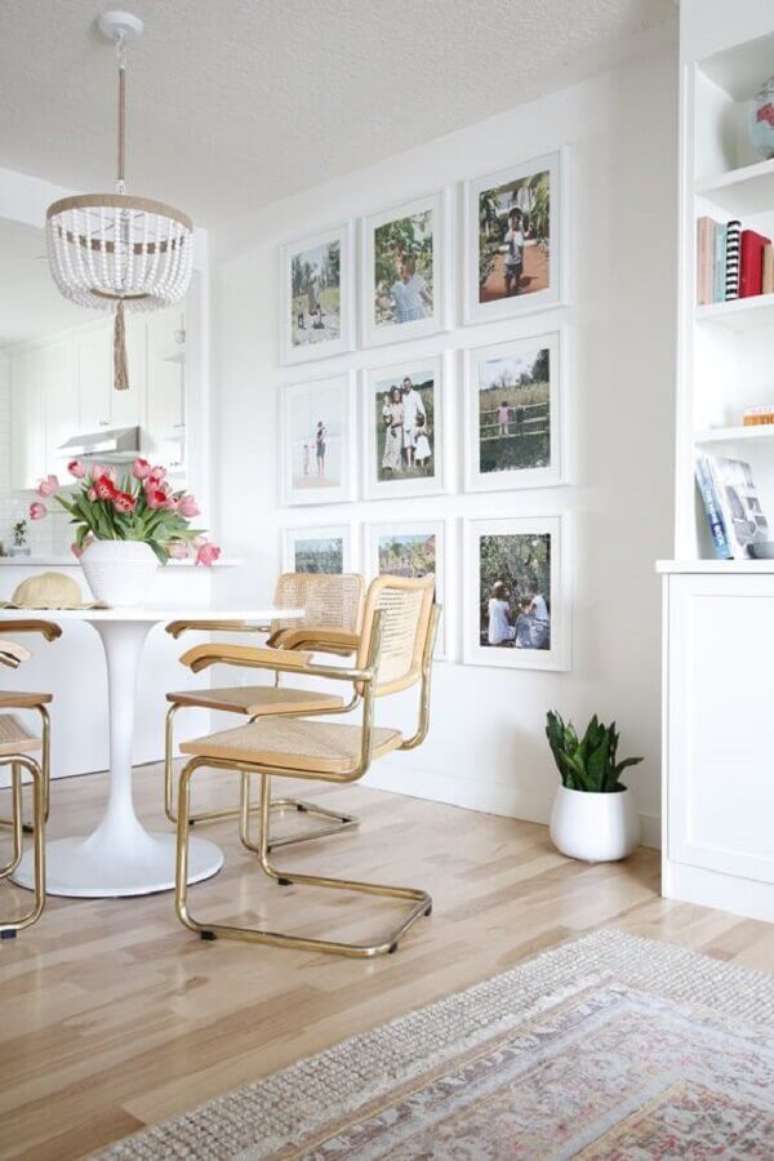 20. Sala de jantar branca e clean decorada com quadros de parede e cadeira com braço – Foto: Home Fashion Trend