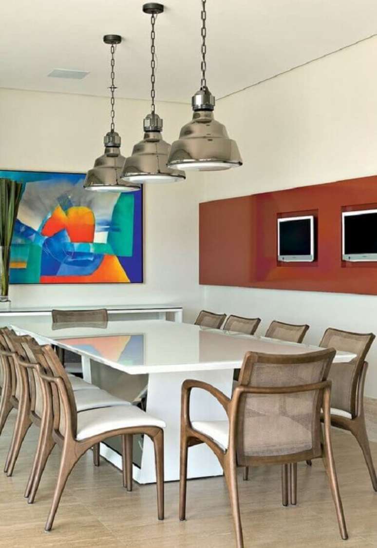 27. Cadeira de madeira com braço para sala de jantar decorada com quadro colorido – Foto: Jeito de Casa