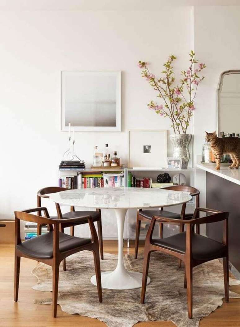 37. Decoração clean para sala de jantar com mesa redonda e cadeira com braço – Foto: Constance Zahn