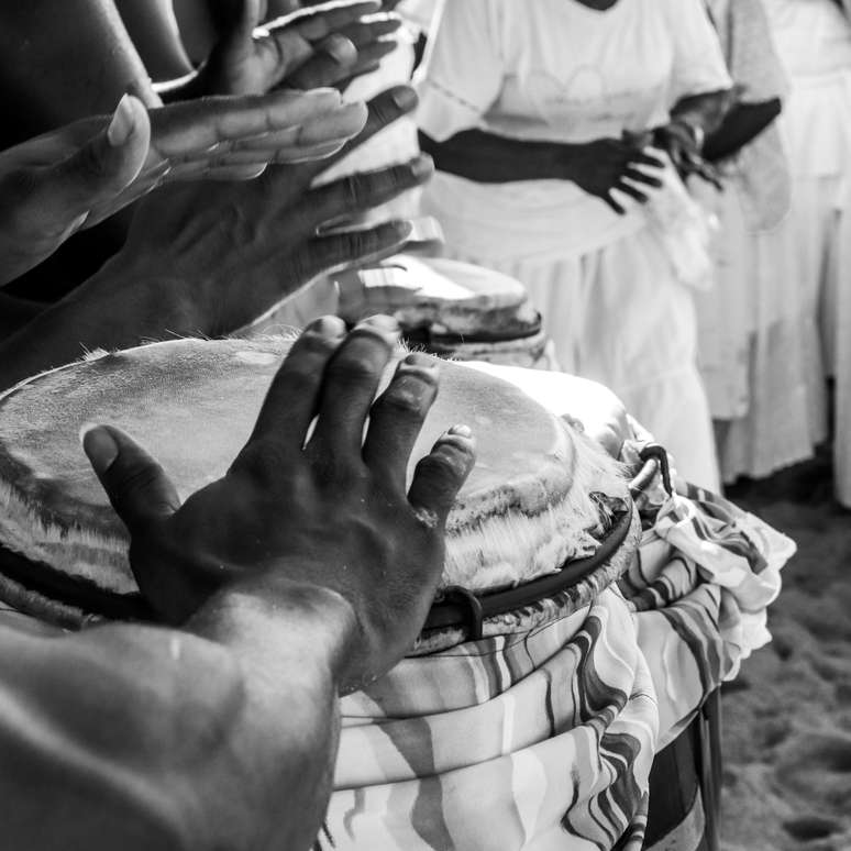 Homem toca atabaque em ritual de umbanda 