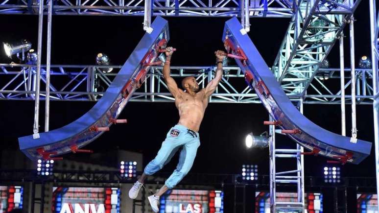 Participante do 'American Ninja Warrior' mostrando seu atletismo ao passar por um obstáculo do circuito (Divulgação)