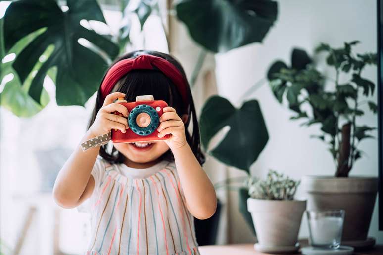 Menina com câmera de brinquedo