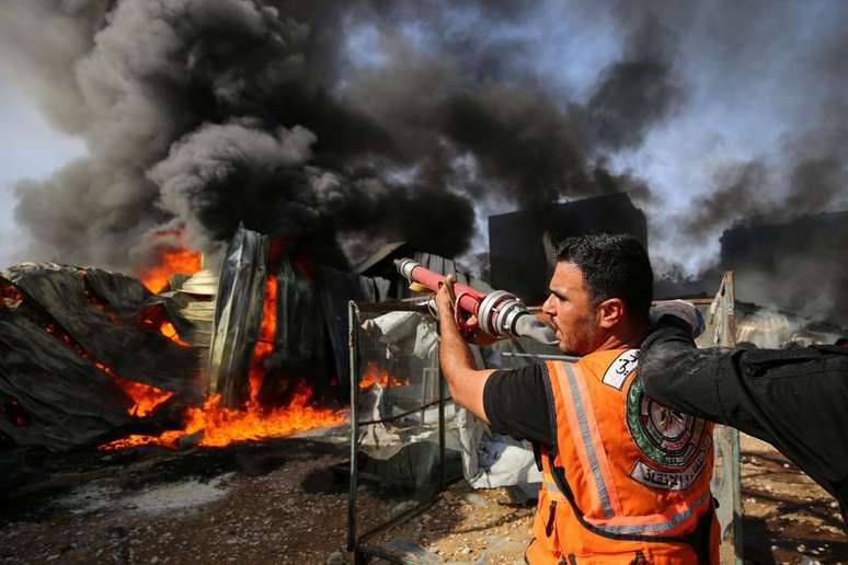 Bombeiros palestinos combatem chamas em fábrica atingida por ataque de Israel em Gaza
17/05/2021
REUTERS/Ashraf Abu Amrah