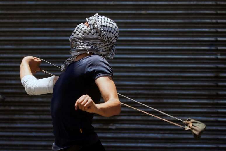 Manifestante palestino atira pedra contra forças israelenses durante protesto em Gaza
18/05/2021
REUTERS/Mussa Qawasma