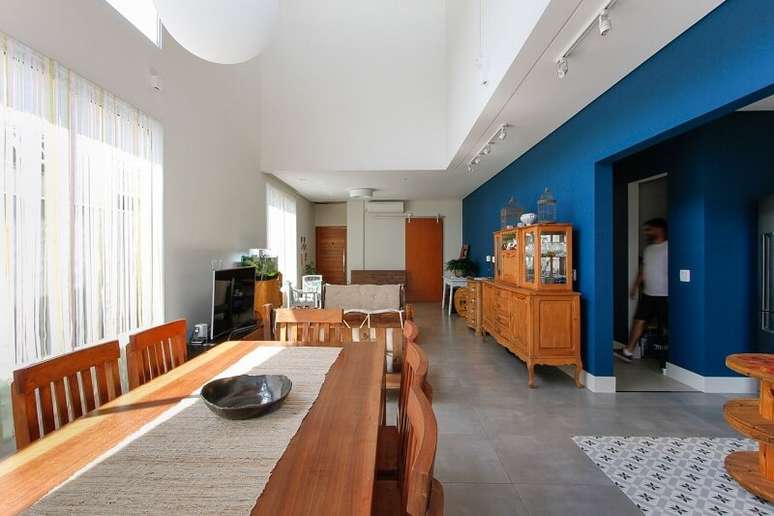 29. Móveis em madeira, piso fosco e paredes azuis marcam a decoração do espaço. Projeto por Otoni Arquitetura