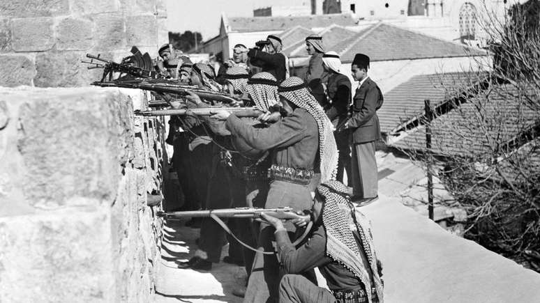 Os soldados das forças aliadas da Legião Árabe atiram contra os combatentes judeus da Haganah, a força de autodefesa da Agência Judaica em março de 1948