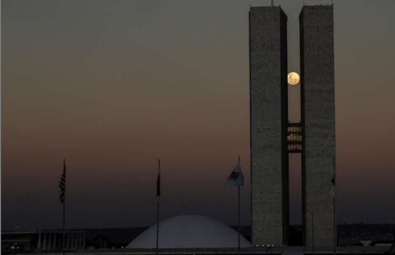 Vista da lua cheia entre as duas torres do pr&eacute;dio do Congresso Nacional, em Bras&iacute;lia, na noite do dia 25