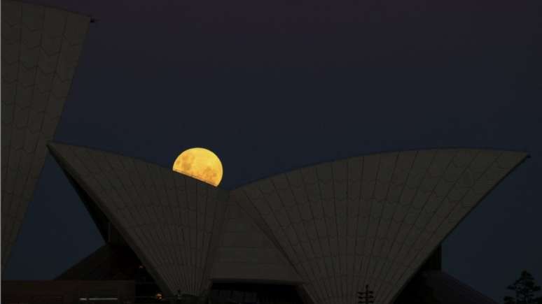 A superlua surge atr&aacute;s da Sydney Opera House em noite de eclipse lunar, em Sydney, na Austr&aacute;lia