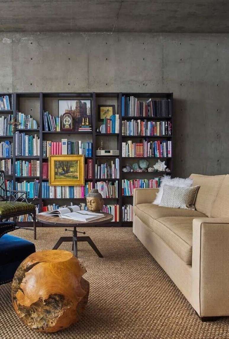 26. Parede de cimento queimado para sala de visita decorada com estante de livros – Foto: Futurist Architecture
