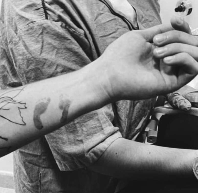 O ator fez quest&atilde;o de 'carimbar' os pezinhos do filho no bra&ccedil;o.